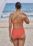 Model on the beach showing the back of the Apex Top and Bound Bottom in Clay