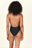 Model standing showing the back of the Micro Trophy One Piece in Black