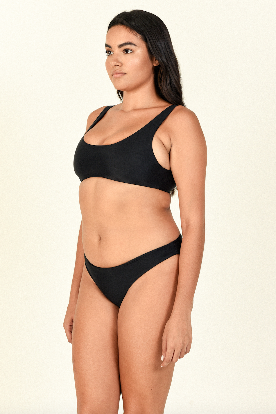 Model standing to the side wearing the Rounded Edges Top and Most Wanted Bottom in Black