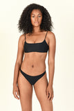 Model standing wearing the Muse Scoop Top and Most Wanted Bottom in Black