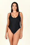 Model standing against background wearing the Contour One Piece in Black