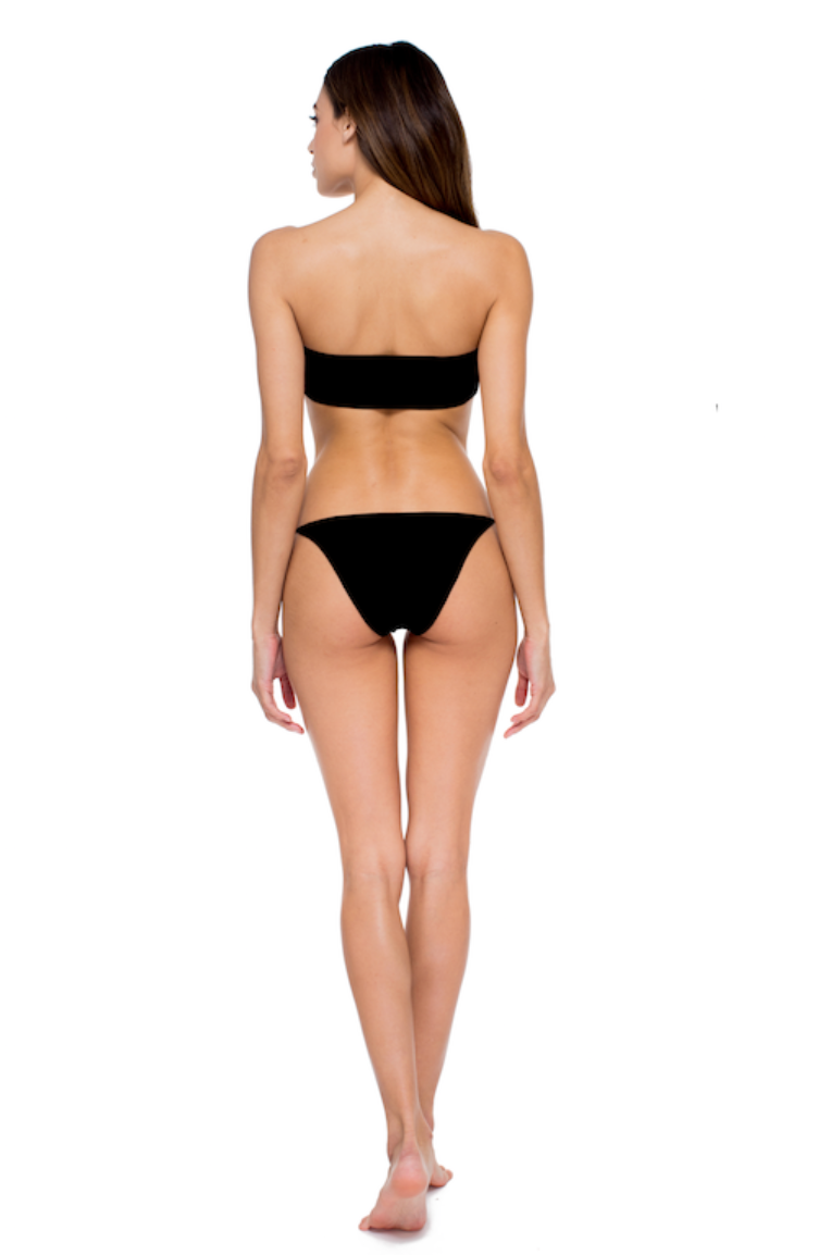 Model posing against white background while showing the back of the All Around Bandeau and Bare Minimum Bottom in Black